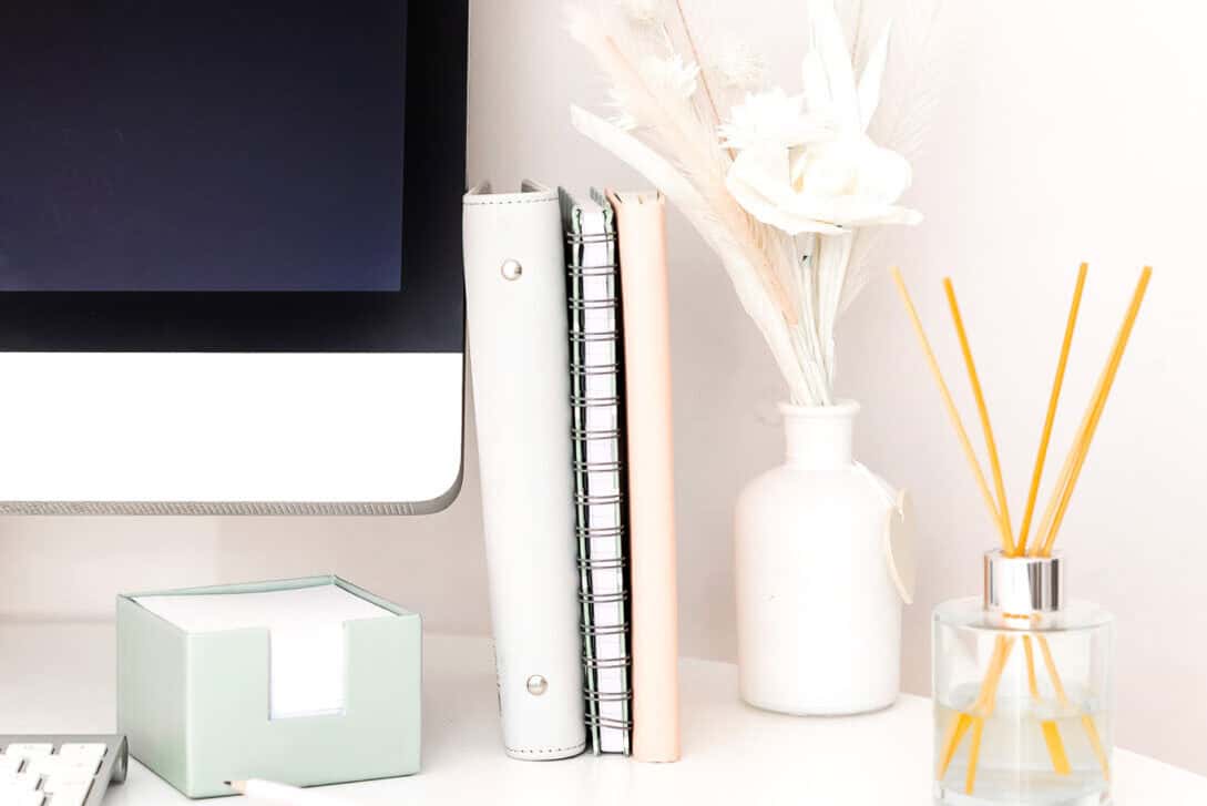 computer-screen-keyboard-notebooks-vase-diffuser-on-white-desk