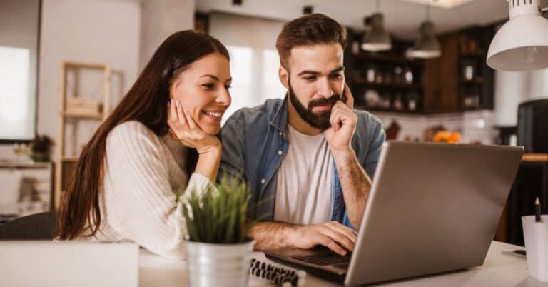 happy couple working from home at their laptop - how to start an amazon FBA business